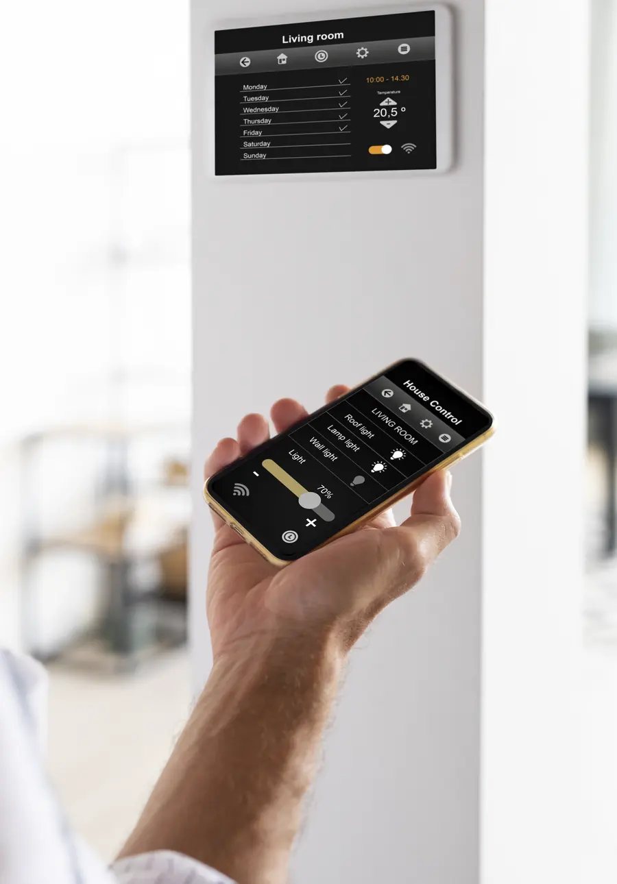 Hand controlling home lighting from a phone, with a touch panel on the wall